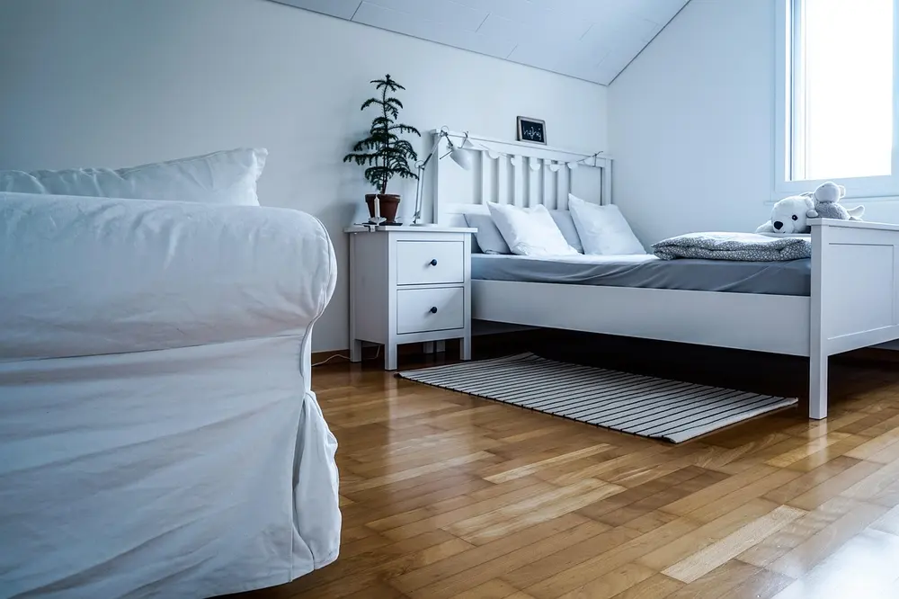 Laminate flooring — bedroom bed dresser white carpet room pillow sleep