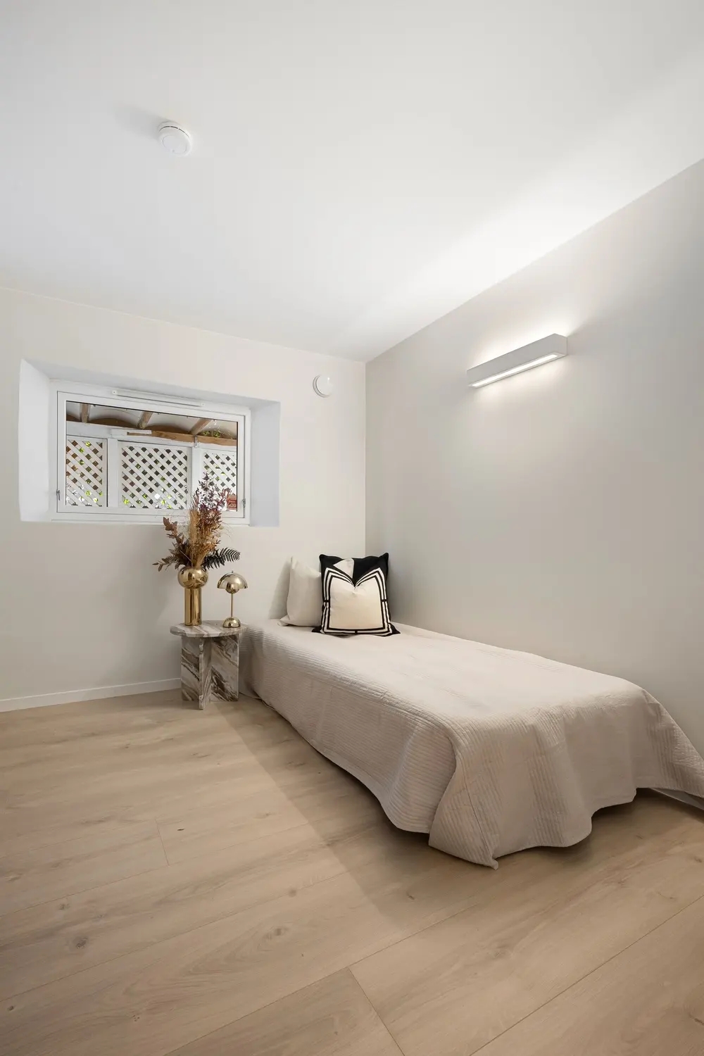 Laminate flooring — bright minimalist bedroom single bed