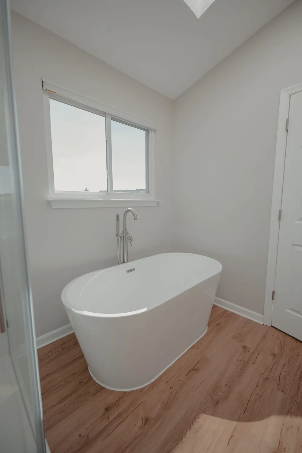 Luxury vinyl plank flooring — bright airy bathroom sleek freestandi