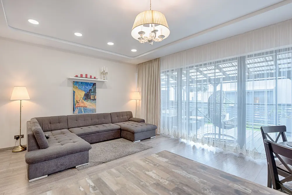 Luxury vinyl plank flooring — bright modern living room large sofa lamp