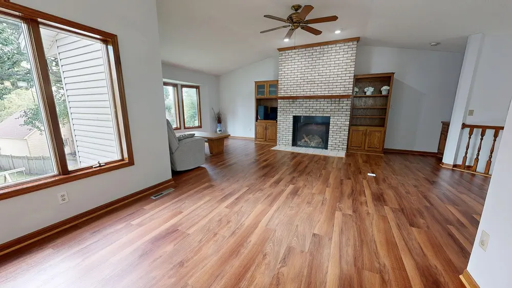 Refinished hardwood flooring — bright living room brick