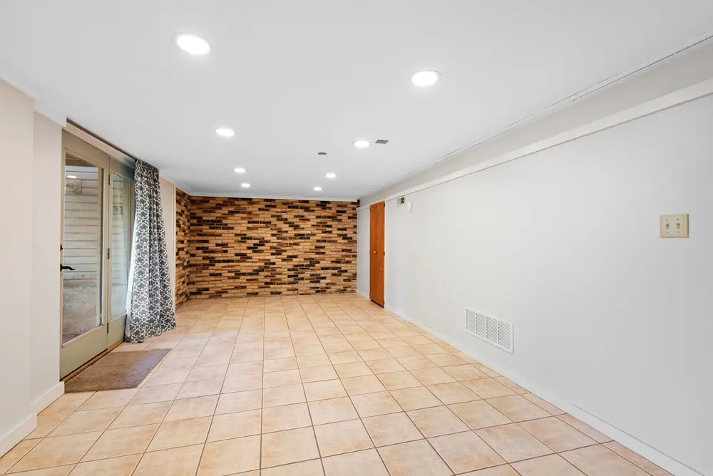 Tile flooring — bright empty basement brick accent wall — near Anaheim, CA