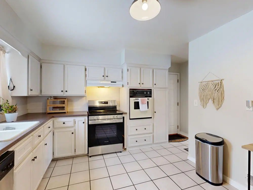 Tile flooring — bright white kitchen stainless steel appliances