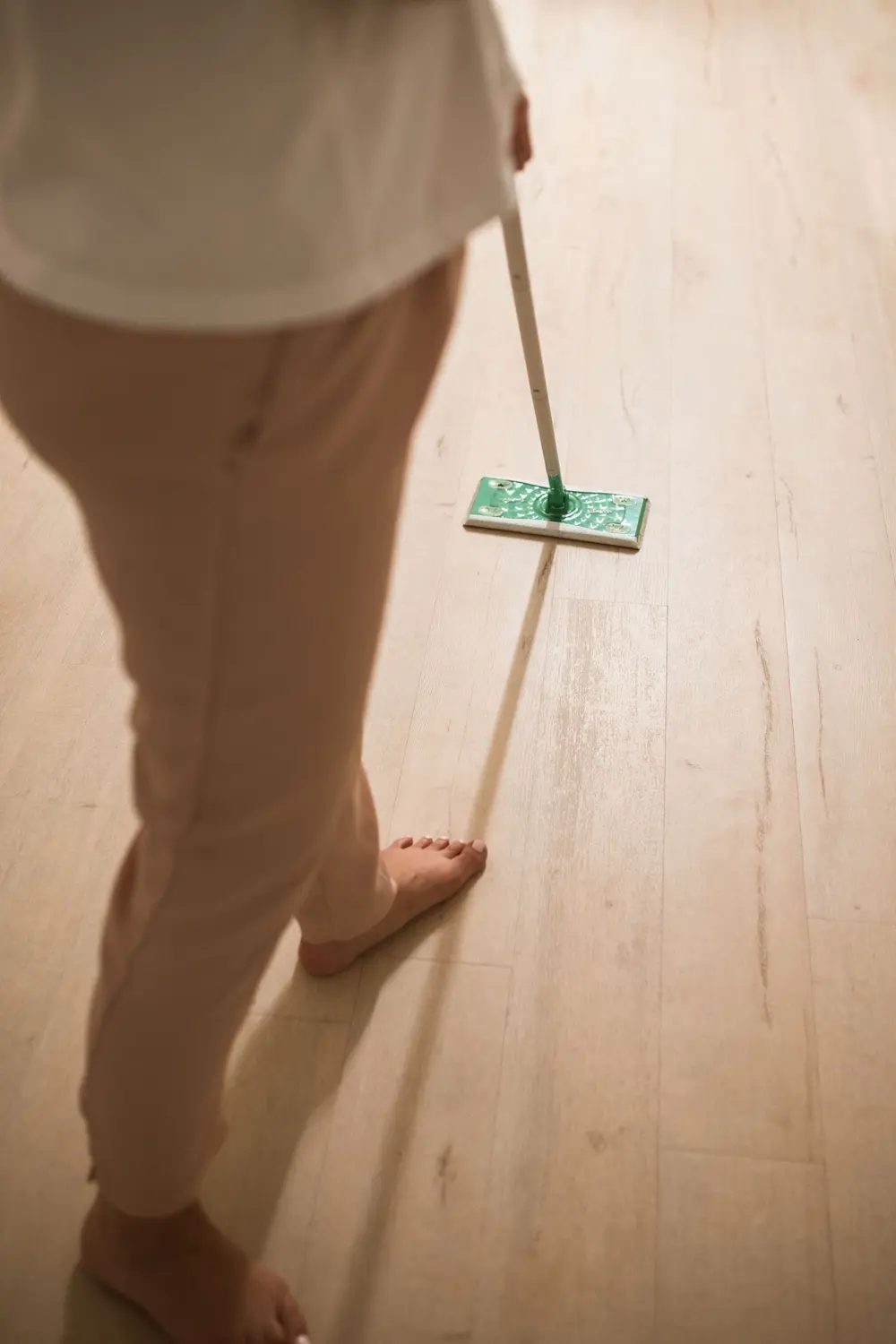 Vinyl flooring — adult cleaning indoors using mop